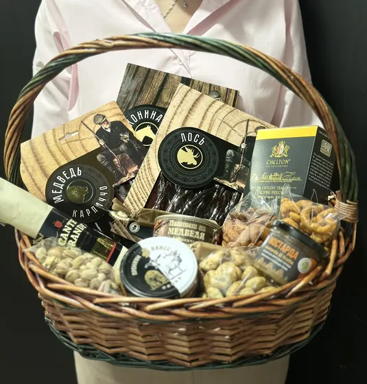 Плетеная корзина с мясными деликатесами, орехами в специях и чаем